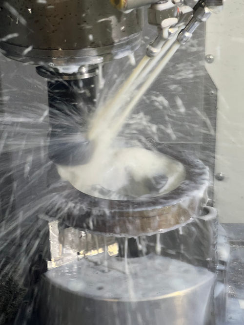 Clutch part being machined under coolant spray