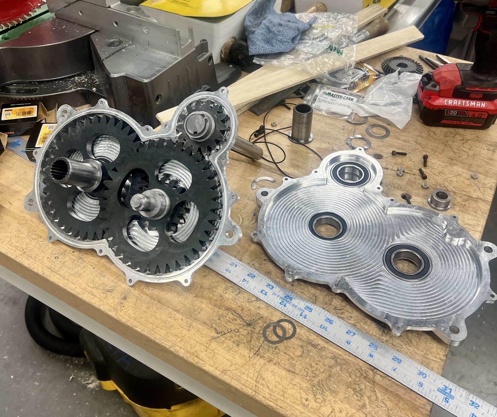 Open gearbox half with the gear train installed, bearing-fitted half alongside