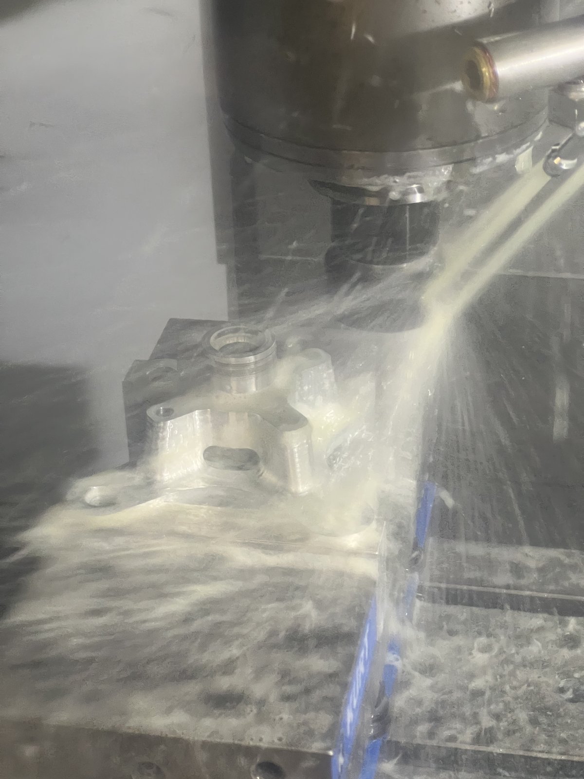 Wheel hub being machined under coolant on the CNC mill